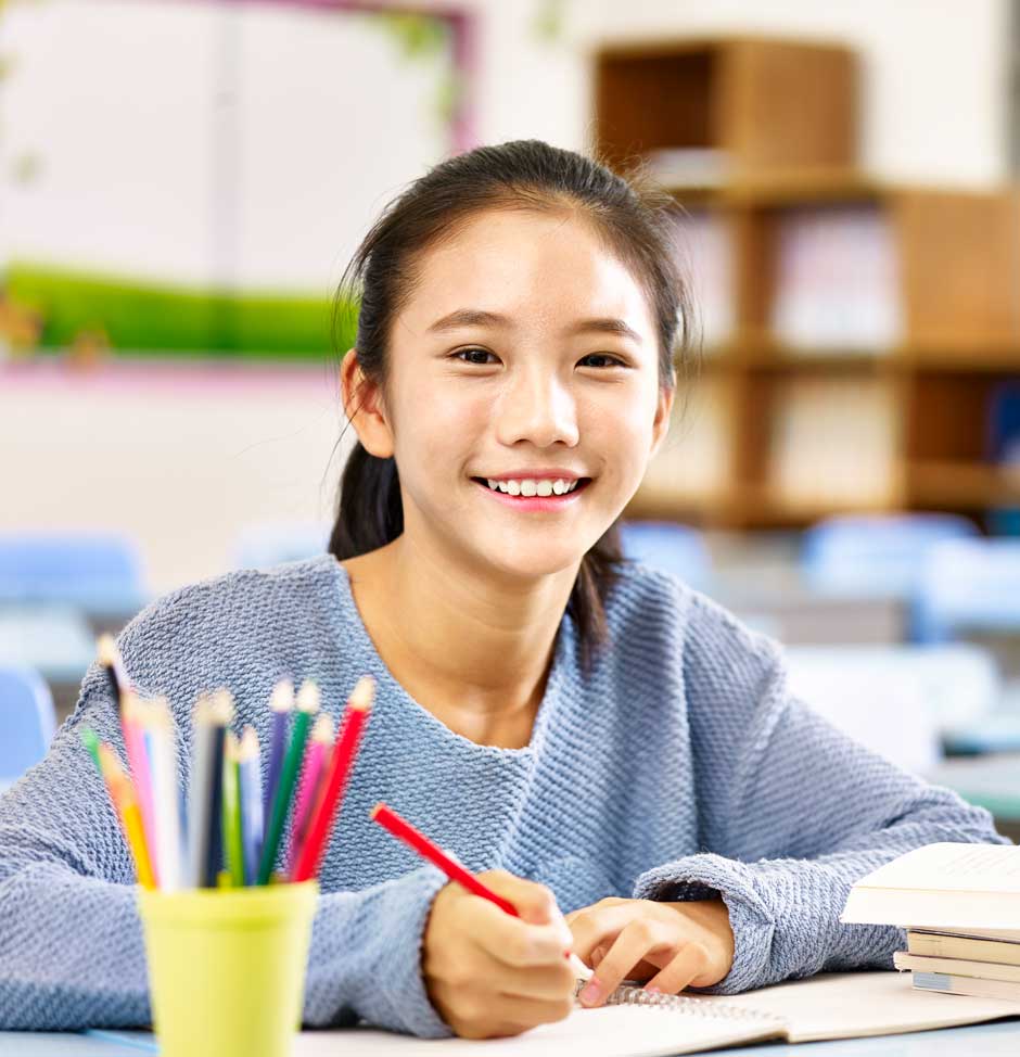 Young girl in class writing some notes